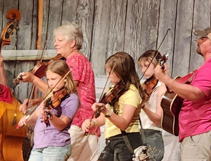 Jayne Huguenin (in purple) jams with fellow fiddlers